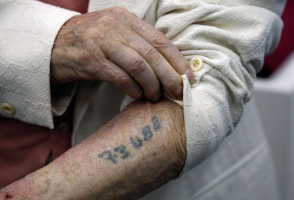  survivor Meyer Hack shows his prisoner number tattooed on his arm.