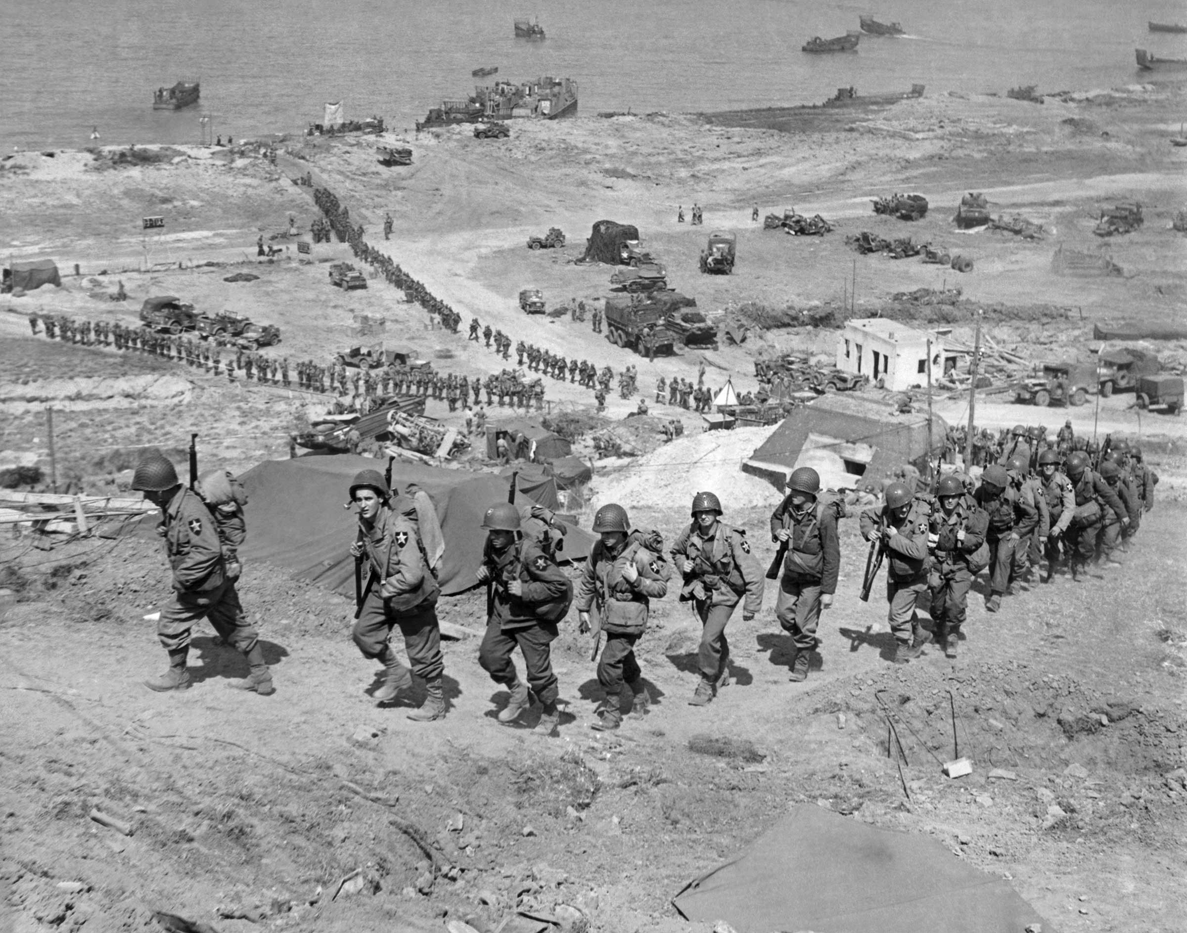 American troops march up from Omaha Beach.