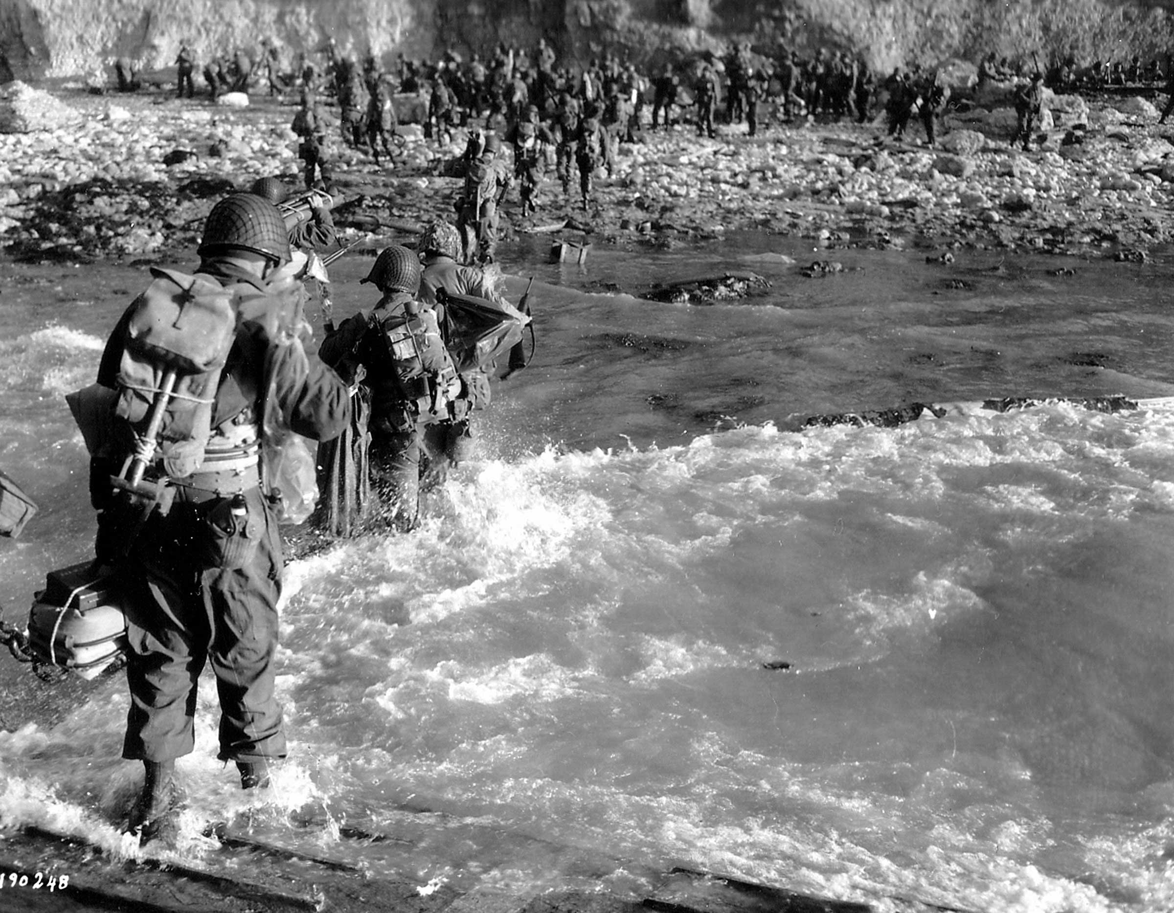 Troops of the 5th Engineer Special Brigade wade through the surf at Fox Green, Omaha Beach.