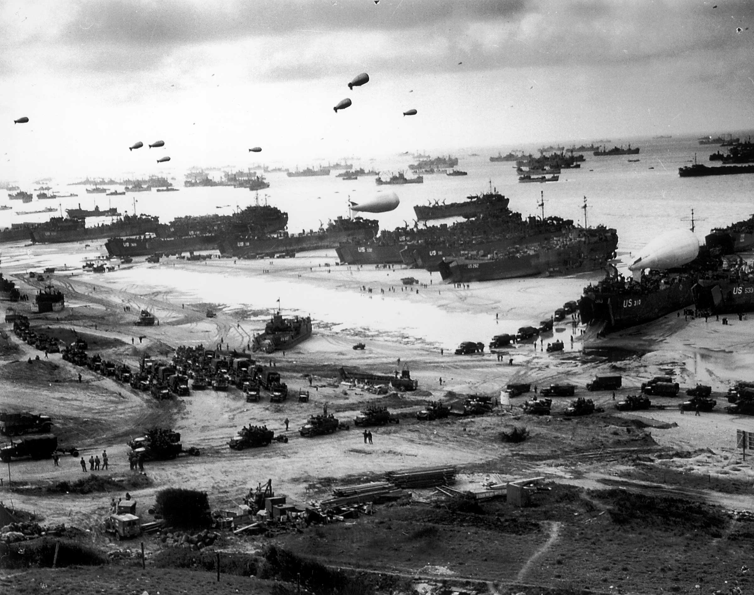 Massive landing and deployment of US troops, supplies and equipment day after D-Day.